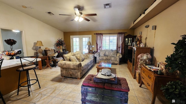 living room with visible vents, a ceiling fan, light tile patterned flooring, and lofted ceiling