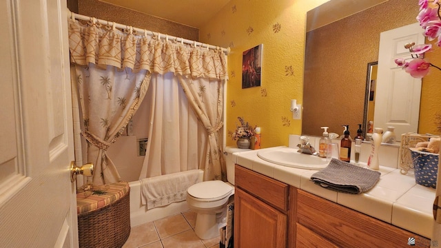 bathroom featuring tile patterned flooring, shower / bath combo, vanity, toilet, and a textured wall