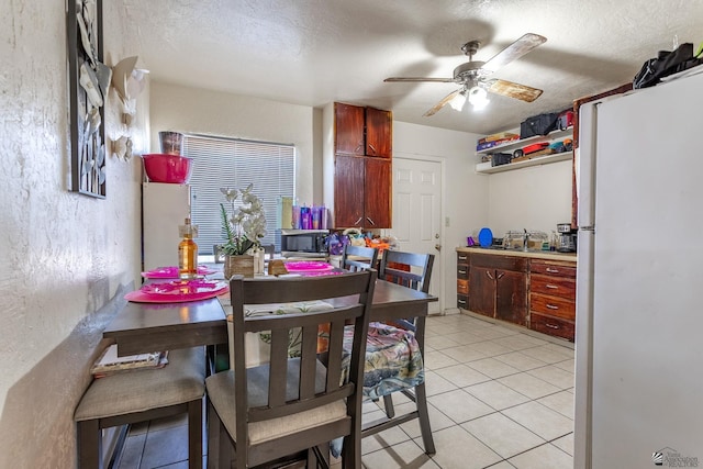 1127 S 13th Ave, Yuma, AZ 85364 - dining space featuring a ceiling fan, light tile patterned floors, a textured wall, and a textured ceiling