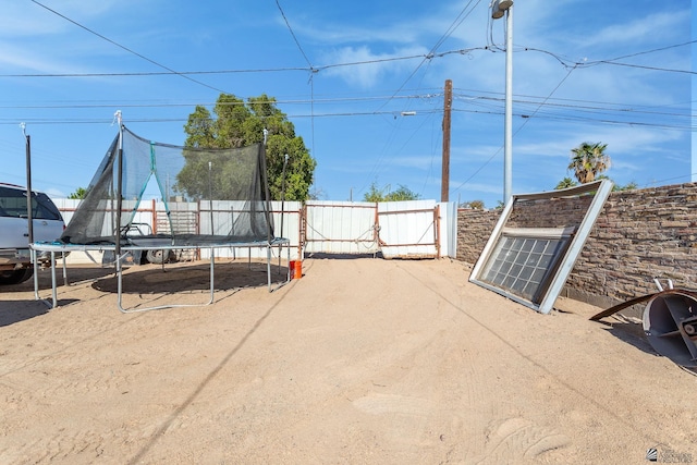 1127 S 13th Ave, Yuma, AZ 85364 - view of patio featuring a trampoline and a gate