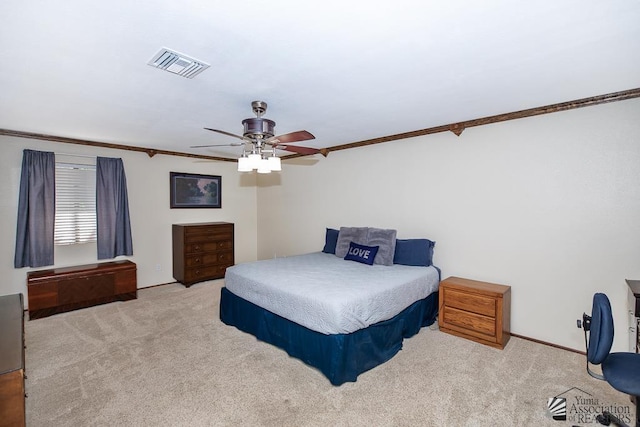 bedroom with carpet floors, ceiling fan, visible vents, and ornamental molding