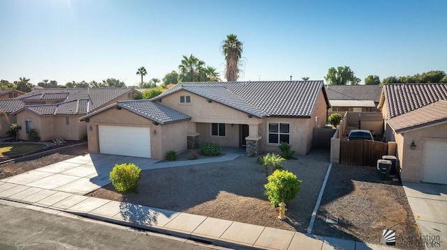 ranch-style house featuring an attached garage, stucco siding, a tile roof, and concrete driveway