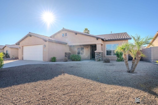 ranch-style house featuring fence, an attached garage, a tile roof, stucco siding, and concrete driveway