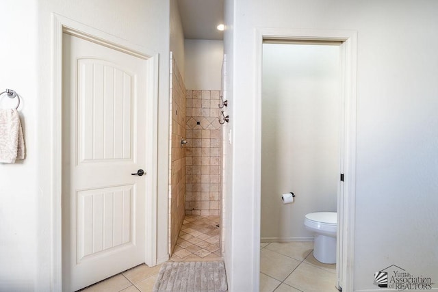 bathroom with a stall shower, tile patterned floors, and toilet