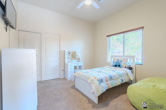 bedroom with ceiling fan, a closet, and light colored carpet