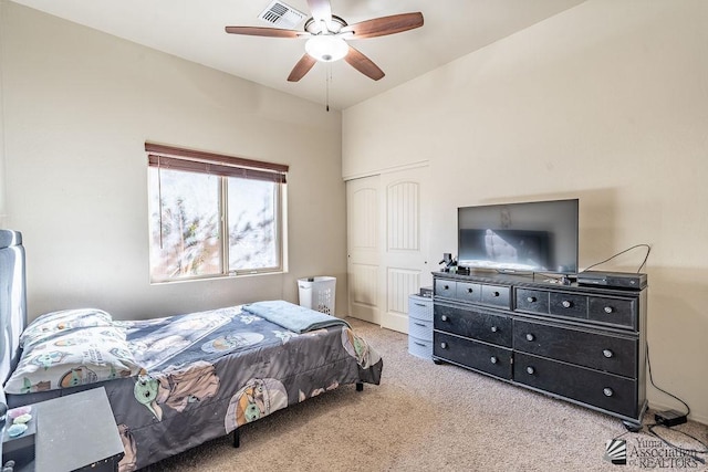 carpeted bedroom with a ceiling fan, a closet, and visible vents
