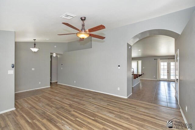 6257 E 47th St, Yuma, AZ 85365 - unfurnished room with arched walkways, a ceiling fan, wood finished floors, and french doors