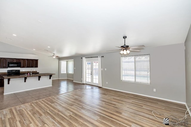 6257 E 47th St, Yuma, AZ 85365 - unfurnished living room with a ceiling fan, light wood-type flooring, vaulted ceiling, and recessed lighting