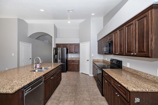 6257 E 47th St, Yuma, AZ 85365 - kitchen with black appliances, a center island with sink, dark brown cabinets, light stone counters, and a high ceiling
