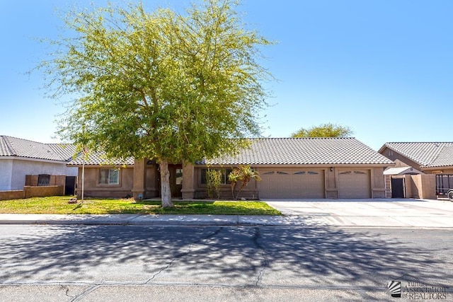 6257 E 47th St, Yuma, AZ 85365 - view of front of house with an attached garage, driveway, a tile roof, and stucco siding
