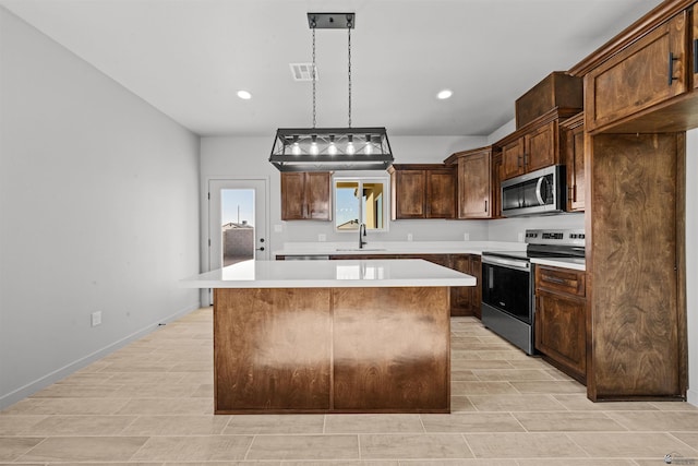 10770 E 45th Ln, Yuma, AZ 85367 - kitchen with appliances with stainless steel finishes, a center island, light countertops, pendant lighting, and recessed lighting