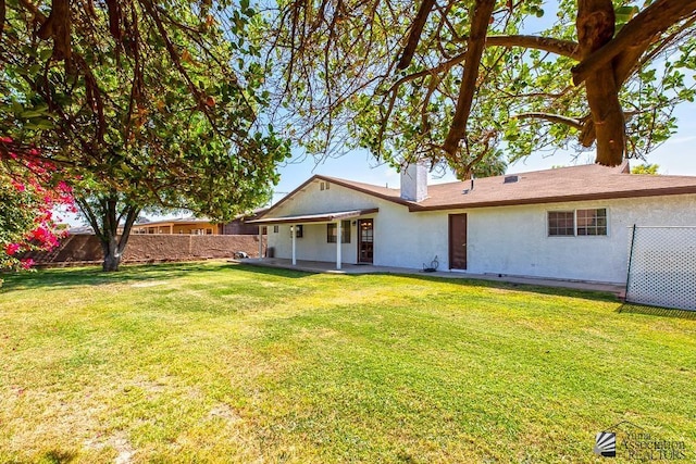 1358 S 22nd Ave, Yuma, AZ 85364 - back of house featuring a patio, a chimney, and stucco siding