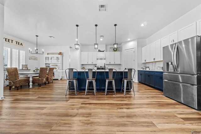 5922 E 47th St, Yuma, AZ 85365 - kitchen with stainless steel fridge with ice dispenser, a chandelier, blue cabinetry, white cabinetry, and recessed lighting