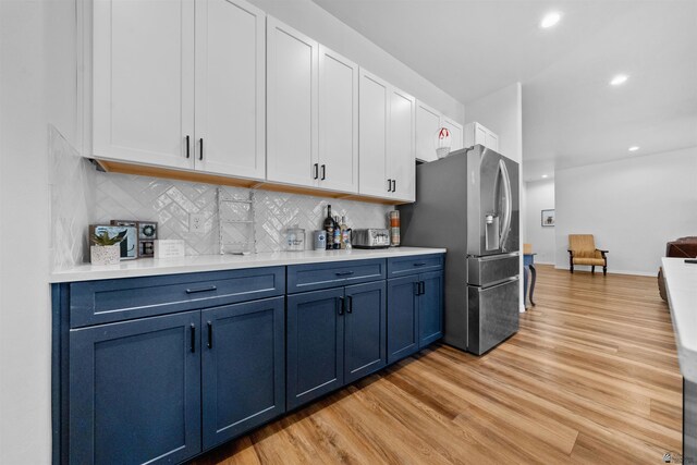 5922 E 47th St, Yuma, AZ 85365 - kitchen featuring stainless steel refrigerator with ice dispenser, blue cabinetry, light wood-style flooring, white cabinetry, and recessed lighting