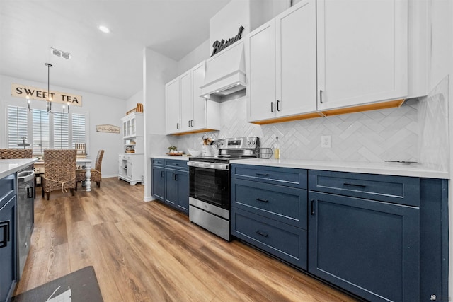 5922 E 47th St, Yuma, AZ 85365 - kitchen with stainless steel range with electric cooktop, light countertops, custom range hood, white cabinets, and decorative backsplash
