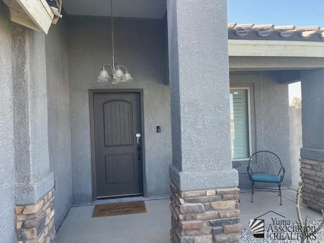 entrance to property featuring stucco siding and stone siding