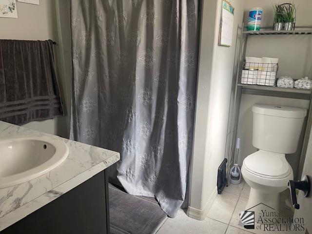bathroom featuring tile patterned floors, vanity, toilet, and curtained shower
