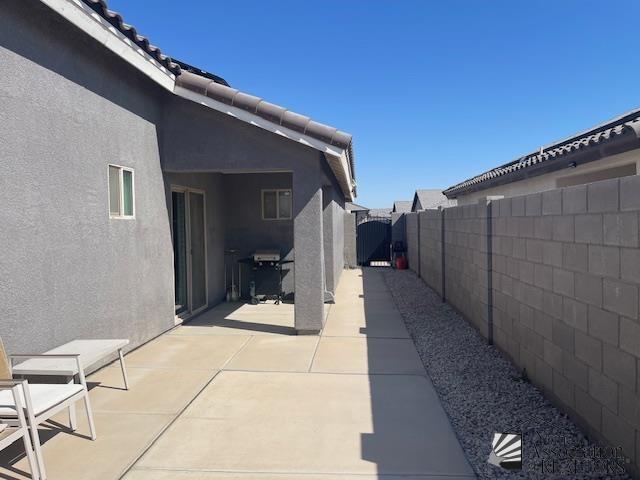 view of patio featuring a fenced backyard, a gate, and area for grilling