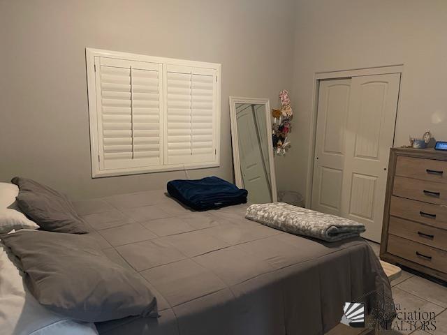 bedroom with light tile patterned floors and a closet
