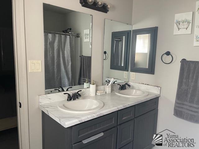full bath featuring double vanity and a sink