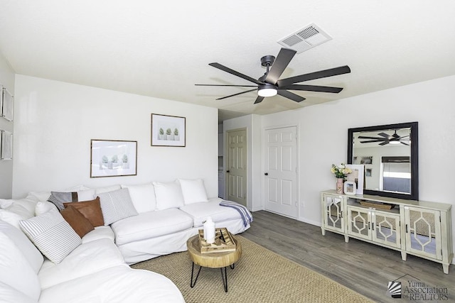 living room featuring a ceiling fan, baseboards, visible vents, and wood finished floors