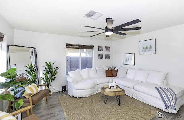 living room with ceiling fan, wood finished floors, and visible vents