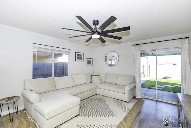 living room featuring ceiling fan, wood finished floors, and a wealth of natural light