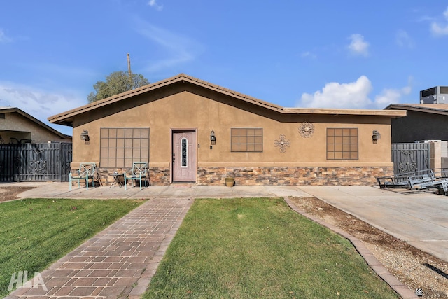 8384 S Yavapai Ln, Yuma, AZ 85364 - view of front of home with fence, a front lawn, a patio, stone siding, and stucco siding