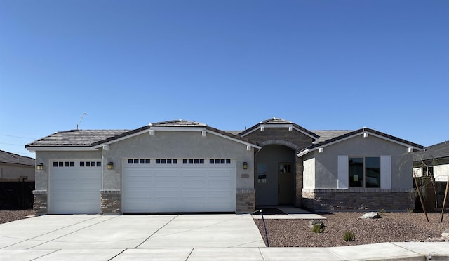 single story home with a garage, stucco siding, driveway, and stone siding