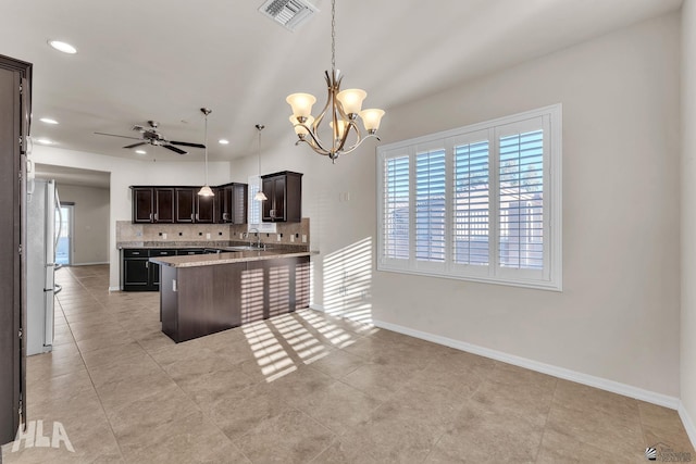 kitchen with a sink, visible vents, decorative backsplash, and a wealth of natural light
