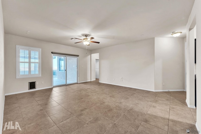 tiled spare room with baseboards and a ceiling fan