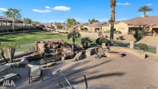 view of patio with a fire pit, fence, and a residential view