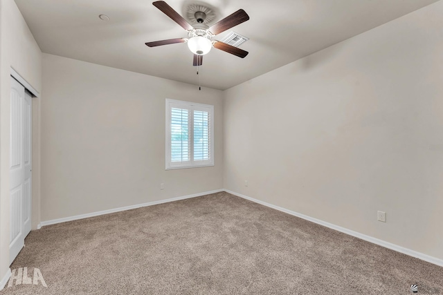 spare room featuring carpet floors, baseboards, ceiling fan, and visible vents
