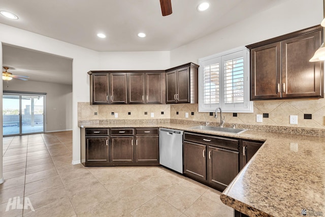 kitchen featuring ceiling fan, dark brown cabinetry, tasteful backsplash, stainless steel dishwasher, and a sink