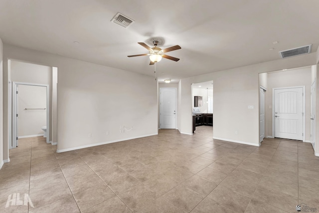 unfurnished bedroom featuring light tile patterned floors, baseboards, ensuite bathroom, and visible vents