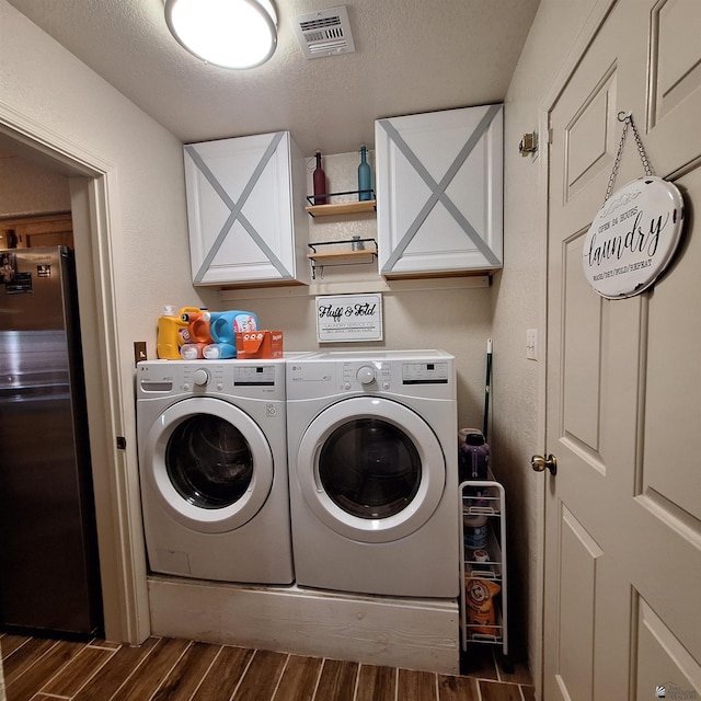 6397 E 42nd St, Yuma, AZ 85365 - laundry room with washing machine and clothes dryer, dark wood-type flooring, cabinet space, and a textured ceiling