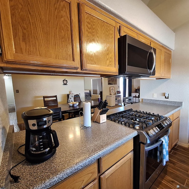 6397 E 42nd St, Yuma, AZ 85365 - kitchen featuring appliances with stainless steel finishes, dark wood-type flooring, and brown cabinetry