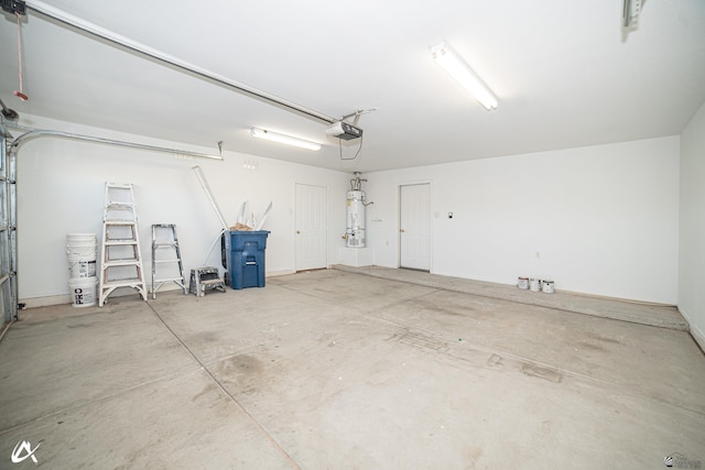 garage featuring strapped water heater and a garage door opener