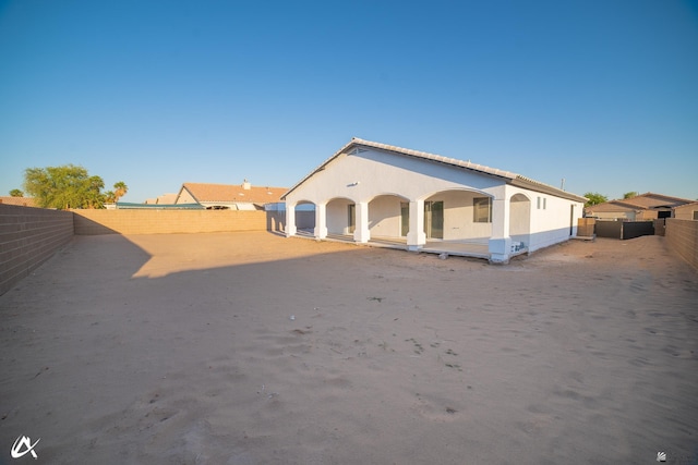 back of property with a fenced backyard and stucco siding