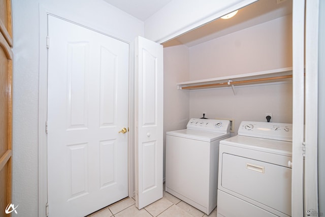 laundry area featuring light tile patterned floors, laundry area, and washing machine and clothes dryer