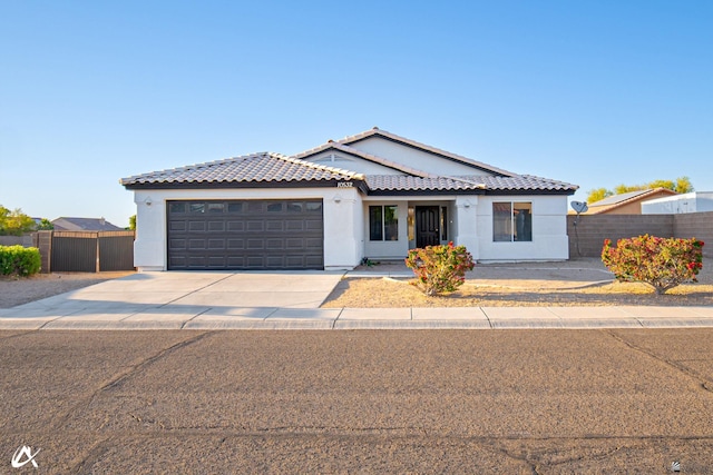ranch-style home with stucco siding, an attached garage, fence, and concrete driveway