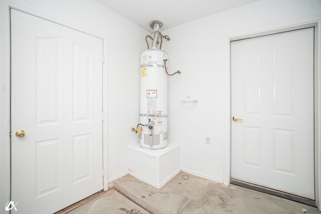 entryway featuring water heater and concrete flooring