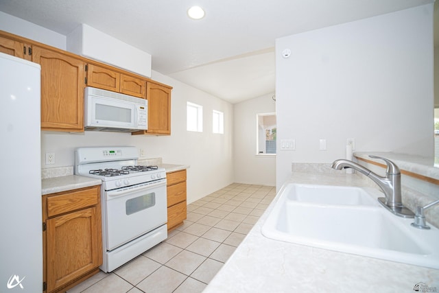 kitchen featuring light tile patterned flooring, white appliances, light countertops, a sink, and vaulted ceiling