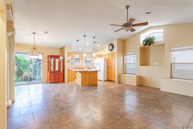 1653 S 42nd Ave, Yuma, AZ 85364 - kitchen featuring white fridge with ice dispenser, a ceiling fan, a center island, vaulted ceiling, and light countertops