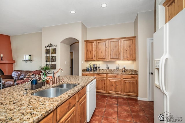 12147 E 33rd St, Yuma, AZ 85367 - kitchen with arched walkways, a sink, dark tile patterned flooring, light stone counters, and white appliances