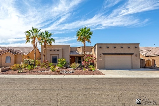 12147 E 33rd St, Yuma, AZ 85367 - pueblo-style home with stucco siding, an attached garage, driveway, and a tiled roof
