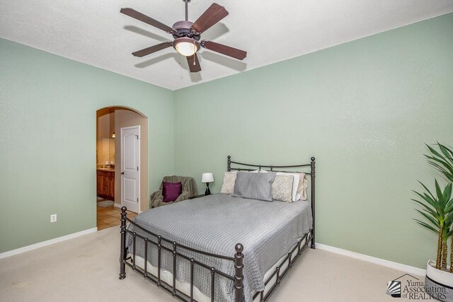 12147 E 33rd St, Yuma, AZ 85367 - carpeted bedroom featuring baseboards, arched walkways, connected bathroom, and ceiling fan