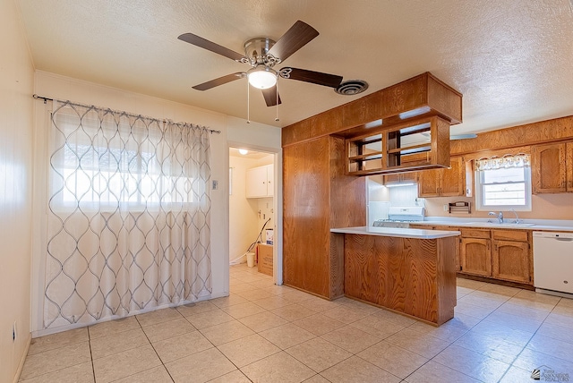 1221 S 10th Ave, Yuma, AZ 85364 - kitchen featuring white appliances, brown cabinets, light countertops, a textured ceiling, and a peninsula