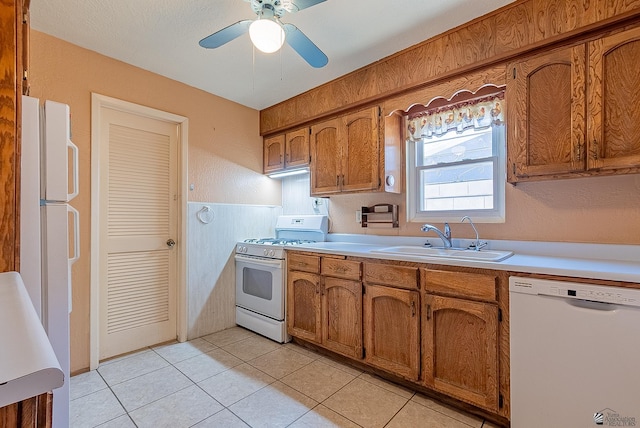 1221 S 10th Ave, Yuma, AZ 85364 - kitchen with white appliances, brown cabinets, light countertops, and a wainscoted wall