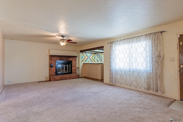 1221 S 10th Ave, Yuma, AZ 85364 - unfurnished living room featuring a ceiling fan, a textured ceiling, carpet, and a brick fireplace